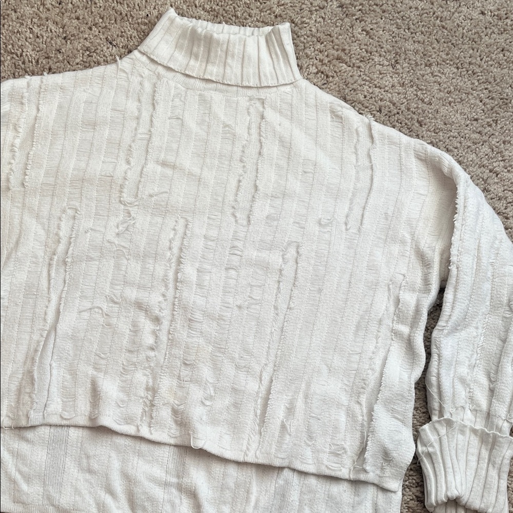 Distressed white turtleneck sweater